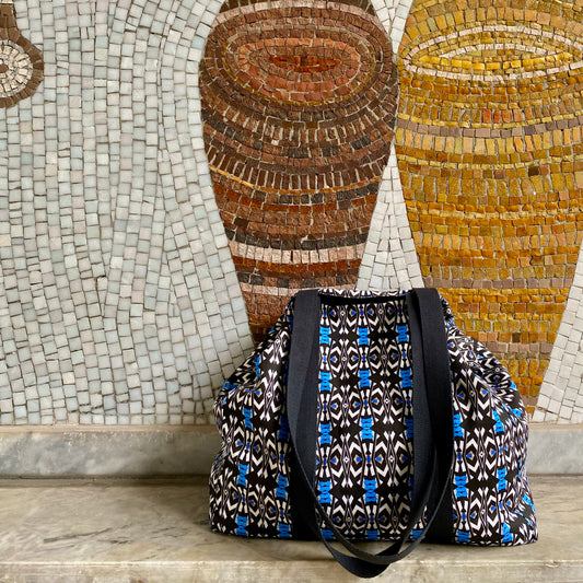 <img src="grand_cabas-molos-vue_-de-cote-pose-sur-banc-en-pierre-la-rue-avec-en-arriere-plan-mosaique-l-oeuf-centre-d-etude_jpeg" alt="