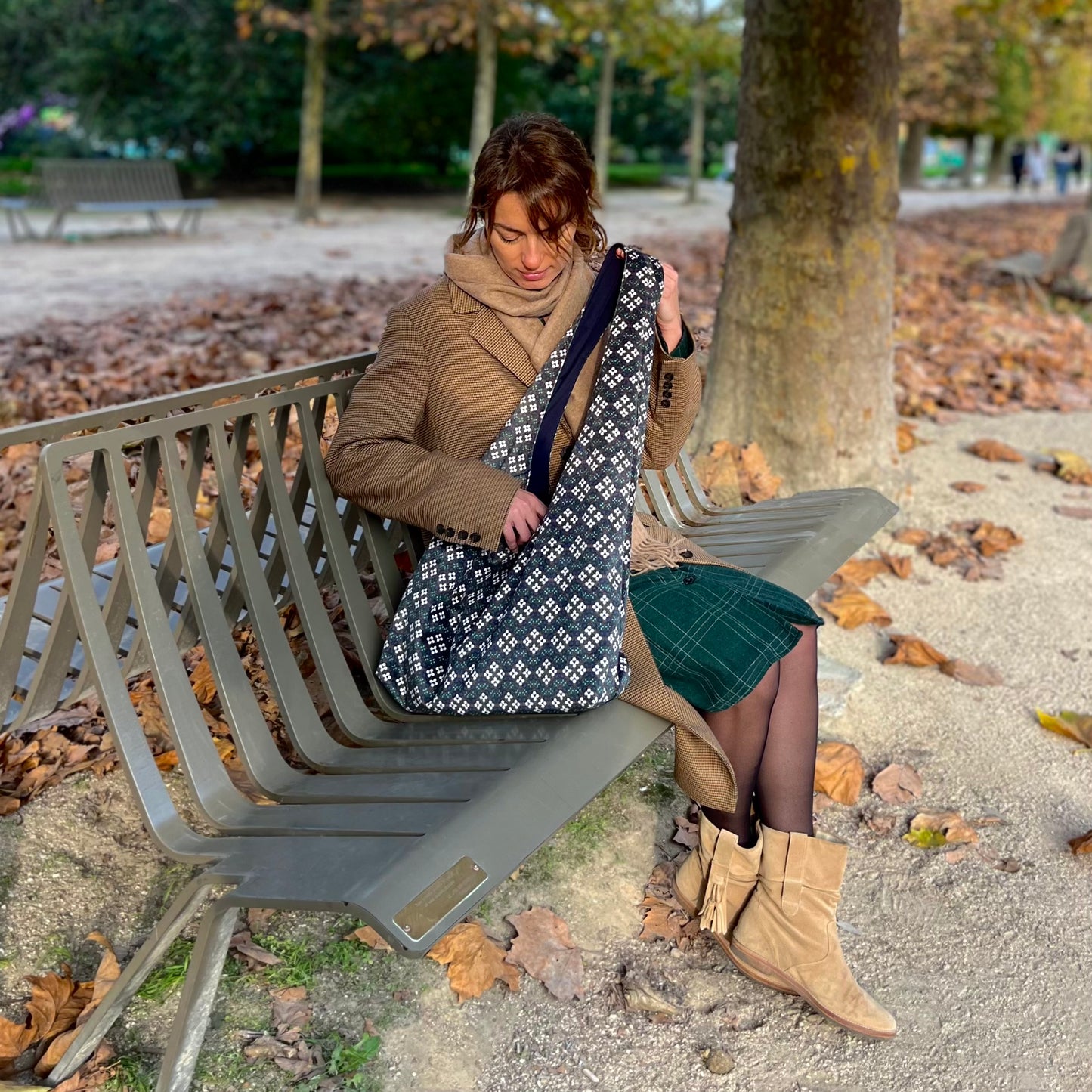 <img src=sac-hobo-hoguette-pose-sur-un-banc-avec-un-modele-qui-cherche-a-l-interieur-entoure-de-feuilles-morte_au-jardin-des-plantes" alt="