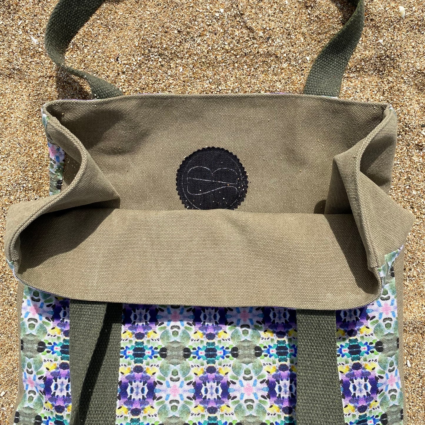 [html] <img src= » cabas-girofle-plan-large-vue-de-haut-interieur-kaki-avec-logo-sezambre-pose-a-plat-sur-sable-plage-et-motif-exterieur-visible_jpg » /> [/html]