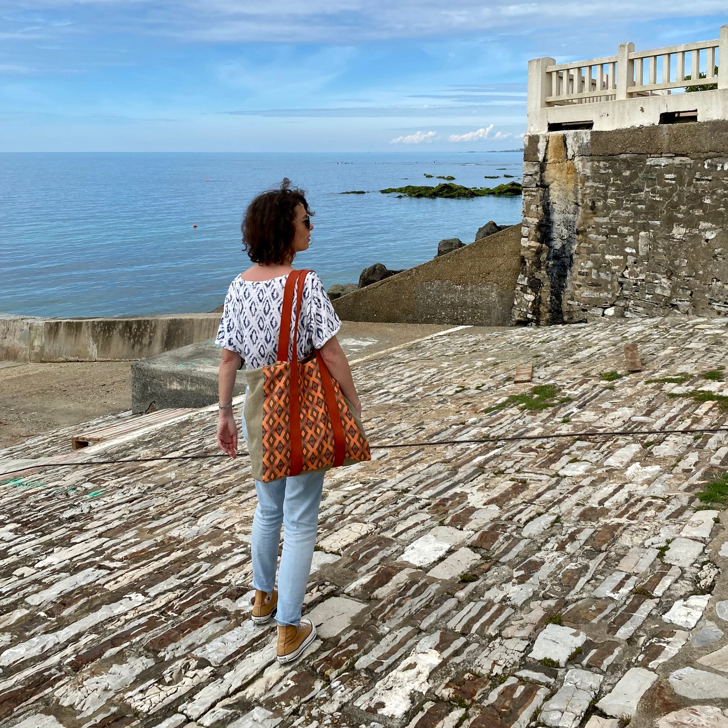 [html] <img src= »grand-cabas-frehel-vue-sur-motif-frehel-et-sangle-couleur-brique-porte-epaule-modele-tee-shirt-blanc-jean-used-cale-solidor-saint-servan» /> [/html]