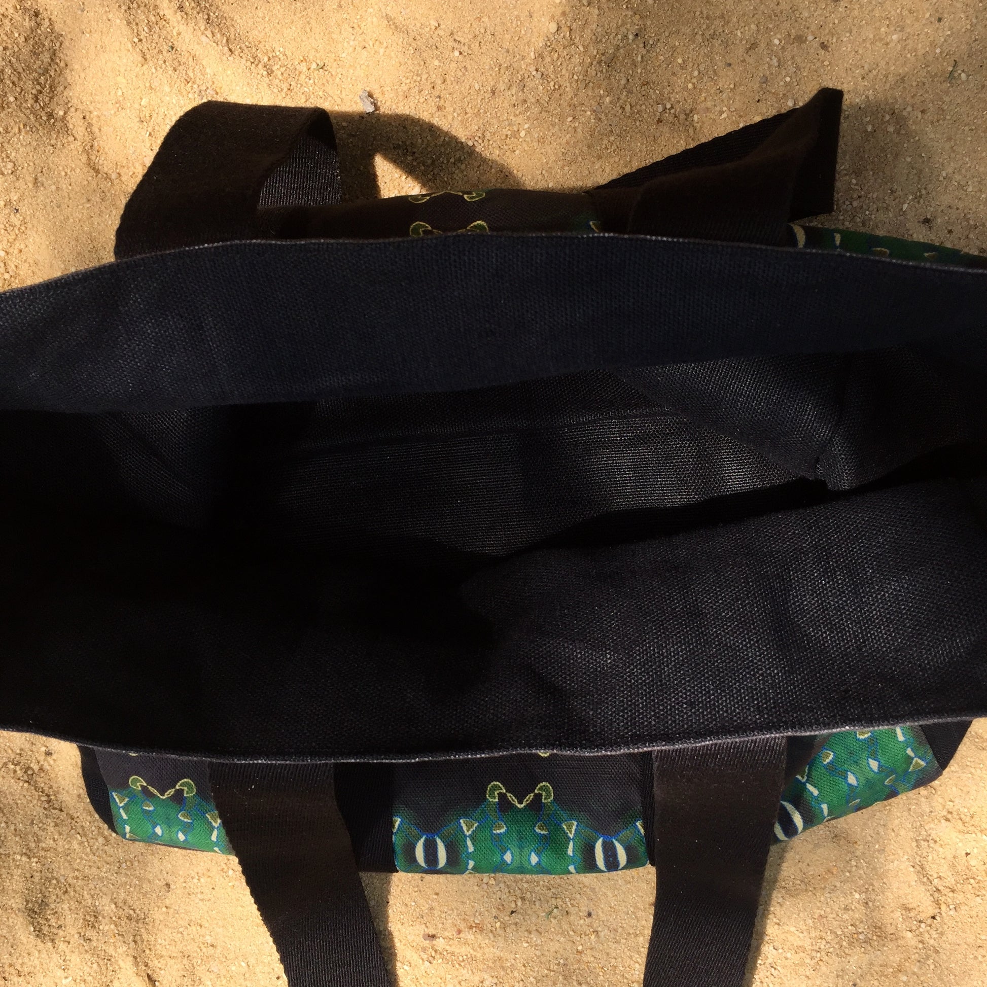 [html] <img src= »cabas-emeraude-vue-dessus-interieur-exterieur-sur-sable_jpg » alt= »cabas émeraude vue de dessus du tissus lin noir avec vue du motif exterieur et de la sangle noire sur le sable » /> [/html]
