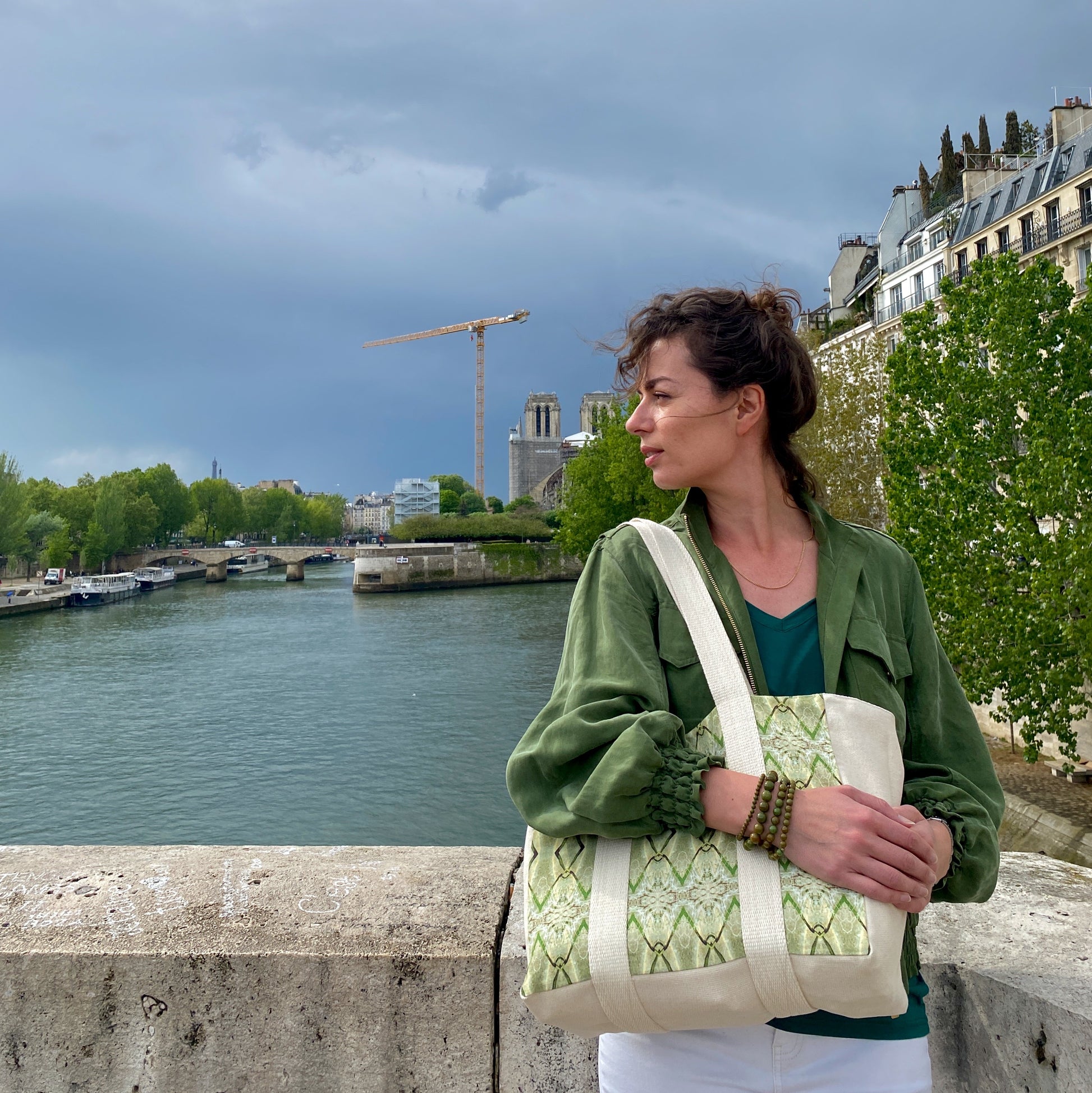 [html] <img src= »cabas-ilya-porte-modele-pont-de-la-tournelle-notre-dame_jpg » alt= »plan large cabas ilya porté par modèle qui porte une veste kaki en tencel et un bracelet en perles kaki dont le bras est posé dessus le cabas sur le pont de la tournelle » /> [/html]